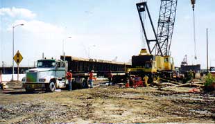 DTI drivers jump in to get first truck tied down and out of the way. Cranes are typically the most expensive piece of equipment on the job.